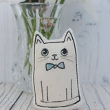 Cute little groom cat figurine wearing a blue bow tie